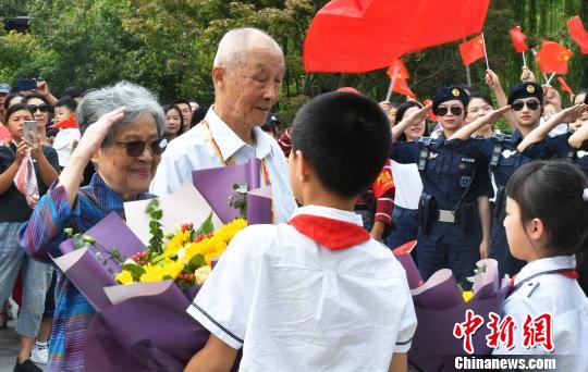 小學生向離休干部獻上鮮花?！堃?攝