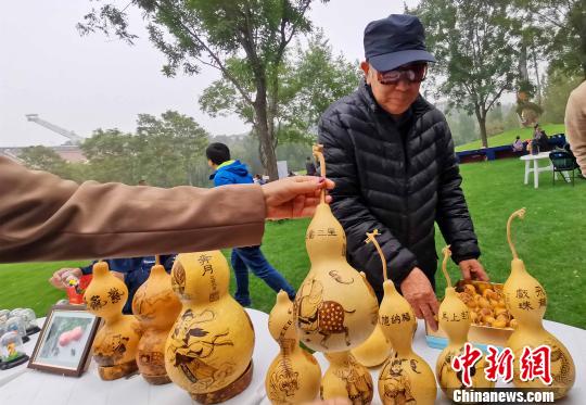 在10月19日開幕的“第二屆金海湖紅葉觀賞季”老北京市集上，有面塑、風(fēng)箏、烙畫葫蘆、瓦當(dāng)制作、拉洋片、刺繡、鏨刻、剪紙、毛猴、發(fā)繡等民俗技藝展示?！堃魂?攝