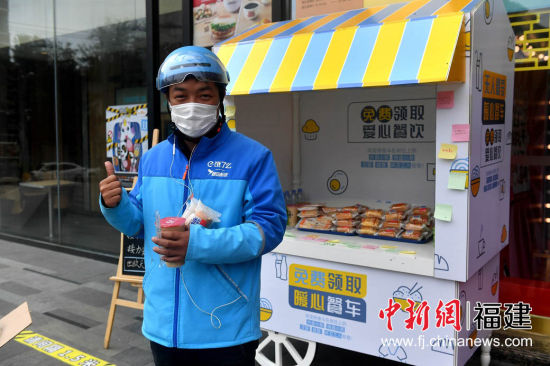 圖為外賣配送員為暖心餐車點贊。 呂明 攝